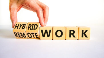 Hybrid or remote work symbol. Businessman turns cubes and changes words 'remote work' to 'hybrid work'. Beautiful white background. Business, hybrid or remote working concept, copy space.