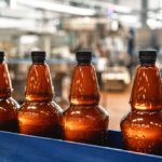 Plastic,Bottles,With,Light,Filtered,Beer,On,The,Conveyor.,Industrial